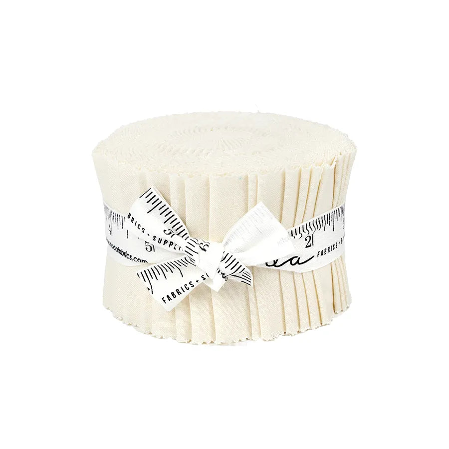 A United Notions Bella Solids Porcelain Junior Jelly Roll, featuring cream-hued strips stacked and tied with a white ribbon printed with a black measuring tape, is displayed against a white background.