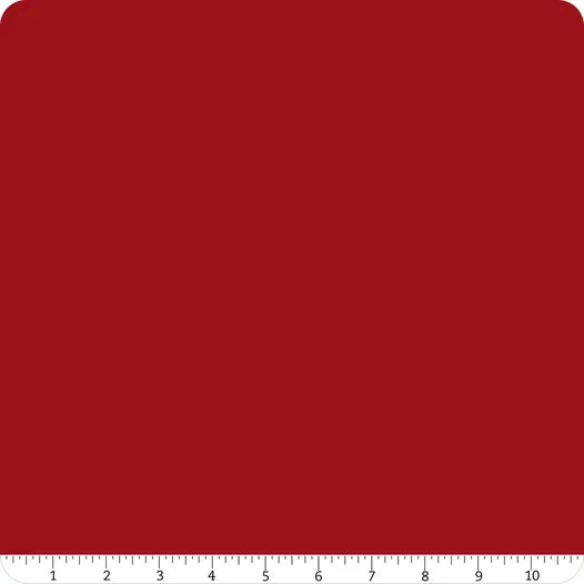 A square of Confetti Cotton™ Cherry Tart solid fabric by Riley Blake with rounded corners. A white ruler marked 1–10 inches runs along the bottom, showing scale—perfect for quilting and sewing projects.