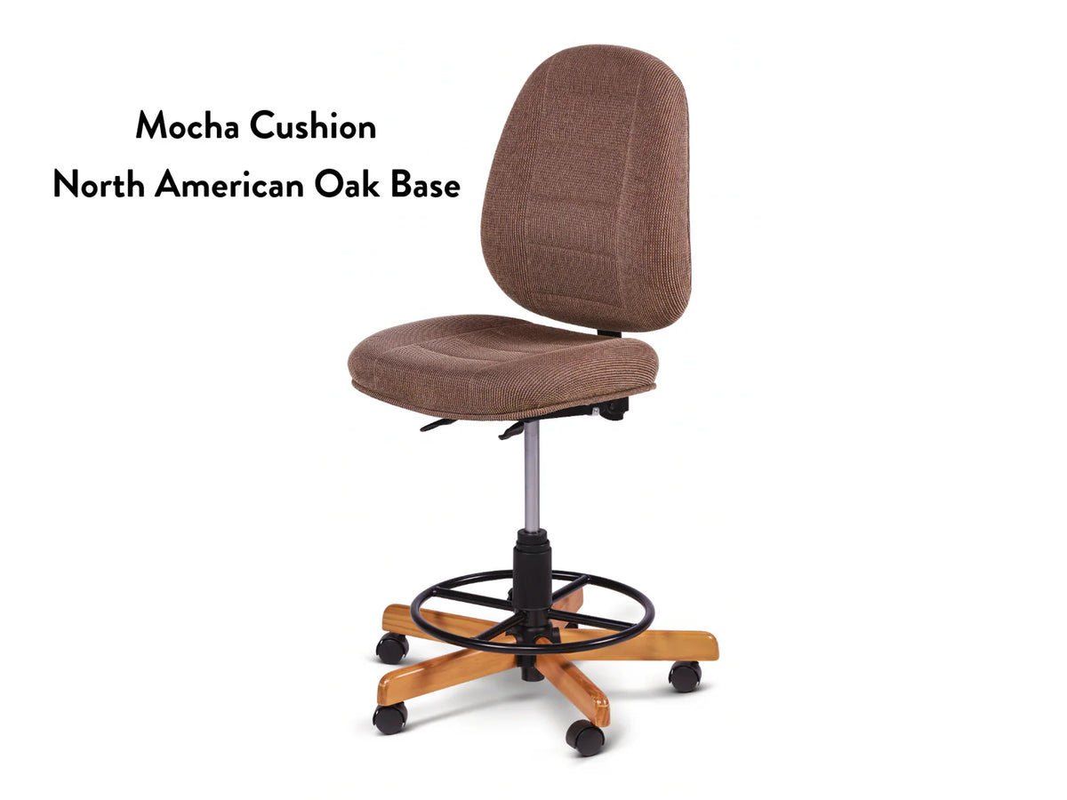 The Koala SewComfort Chair features an ergonomic tall backrest, mocha cushion, and a North American oak wood base with five wheels and a black circular footrest. Text on the left reads: “Mocha Cushion North American Oak Base.”.