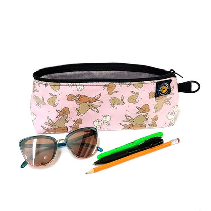 Pencil case with fairy pattern, sunglasses, and pens on a white background