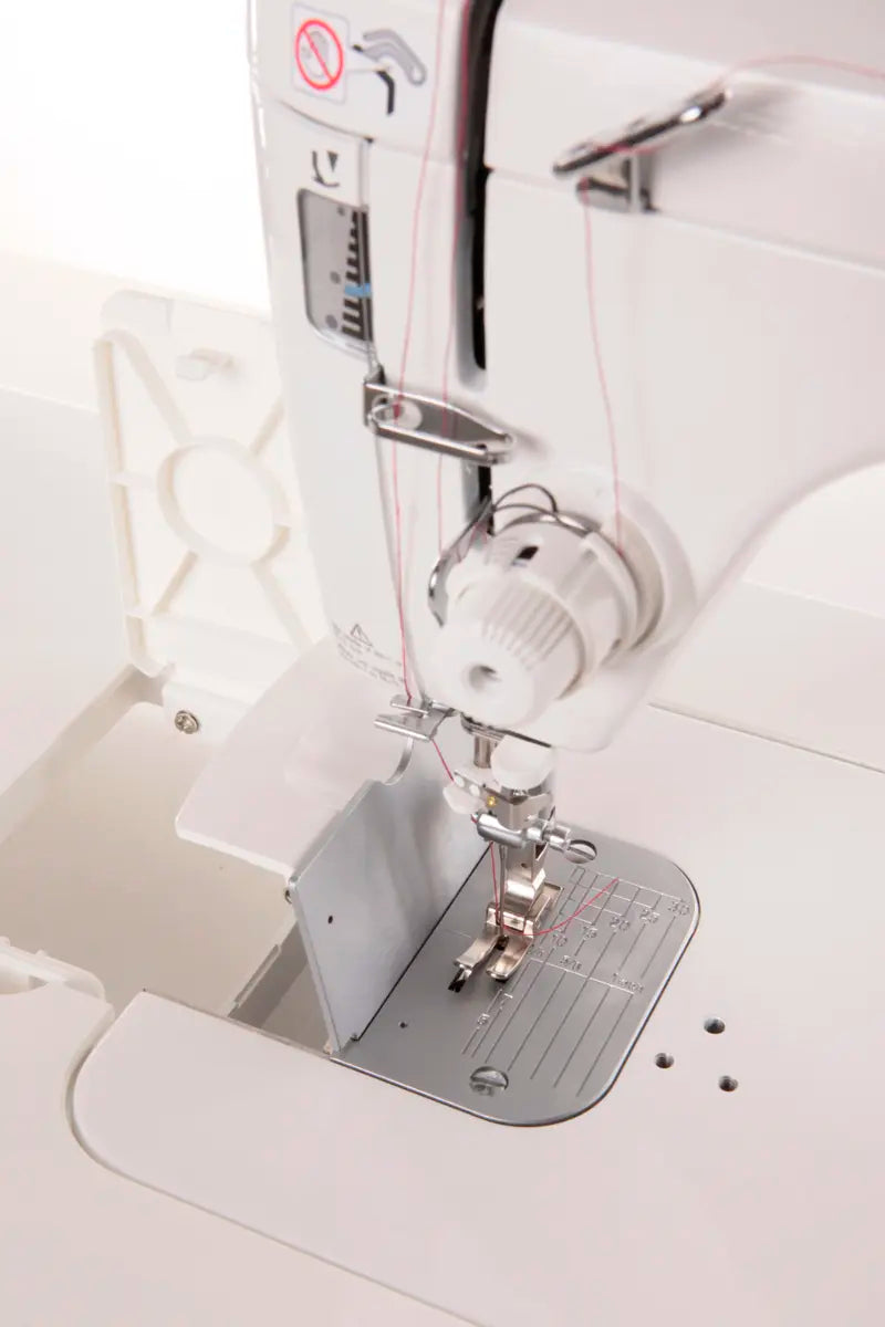 Close-up of the JUKI TL-2000Qi Sewing and Quilting Machine, featuring the needle, presser foot, thread area, and part of the stitch plate.