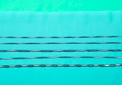 Five parallel rows of surgical sutures in light blue fabric display stitching patterns made with the Baby Lock Triumph Serger Machine, all set on a turquoise background.