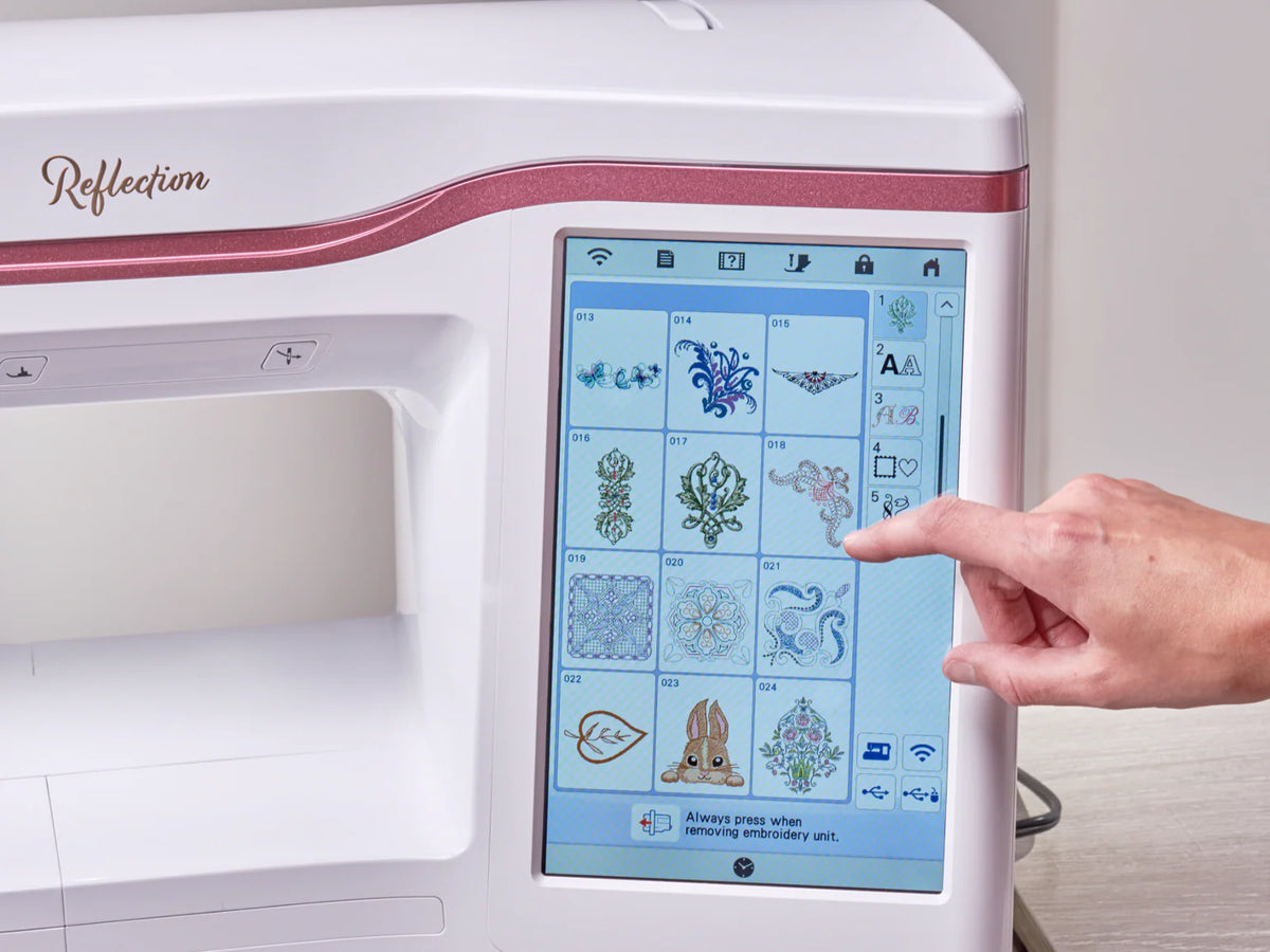 A hand selects an embroidery pattern on the touchscreen of the Baby Lock Reflection Sewing & Embroidery machine, highlighting its wide design options, large embroidery field, and 60 days of FREE online classes.