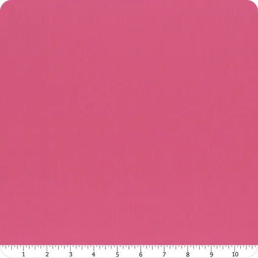 A square piece of Confetti Cotton™ Passion Solid Fabric Yardage by Riley Blake is displayed with rounded corners. A white ruler marked 1–10 inches along the bottom edge shows the scale of this quilting cotton.