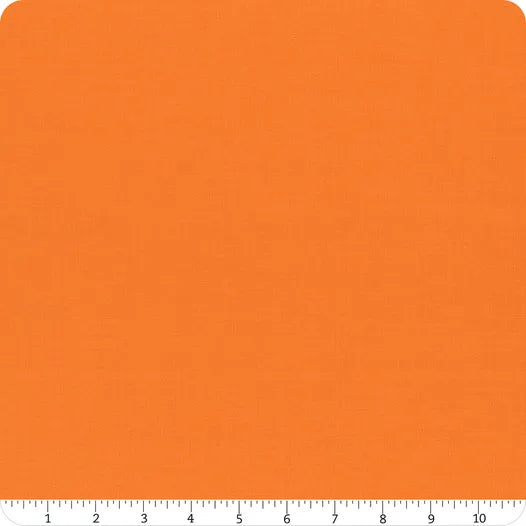 A square swatch of Riley Blake's Confetti Cotton™ Tangerine Solid Fabric Yardage is shown with a white ruler (0–10 inches) along the bottom edge. The fabric has a subtle texture and rounded corners.