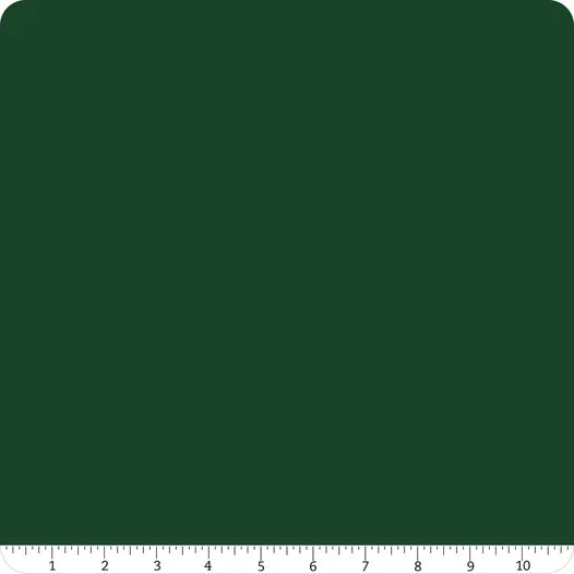 A square, dark green mat with rounded corners and a white ruler (1–10) is perfect for cutting Confetti Cotton™ Woodland Solid Fabric Yardage by Riley Blake.