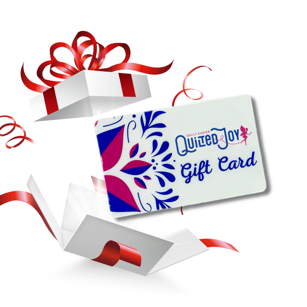 A gift card labeled Quilted Joy Gift Card emerges from an open white gift box decorated with a red ribbon and bow, with sparkles and ribbon accents in the background.