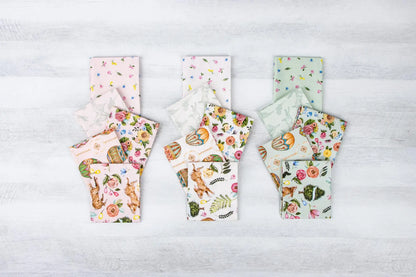 Set of floral-patterned products on a light wooden surface