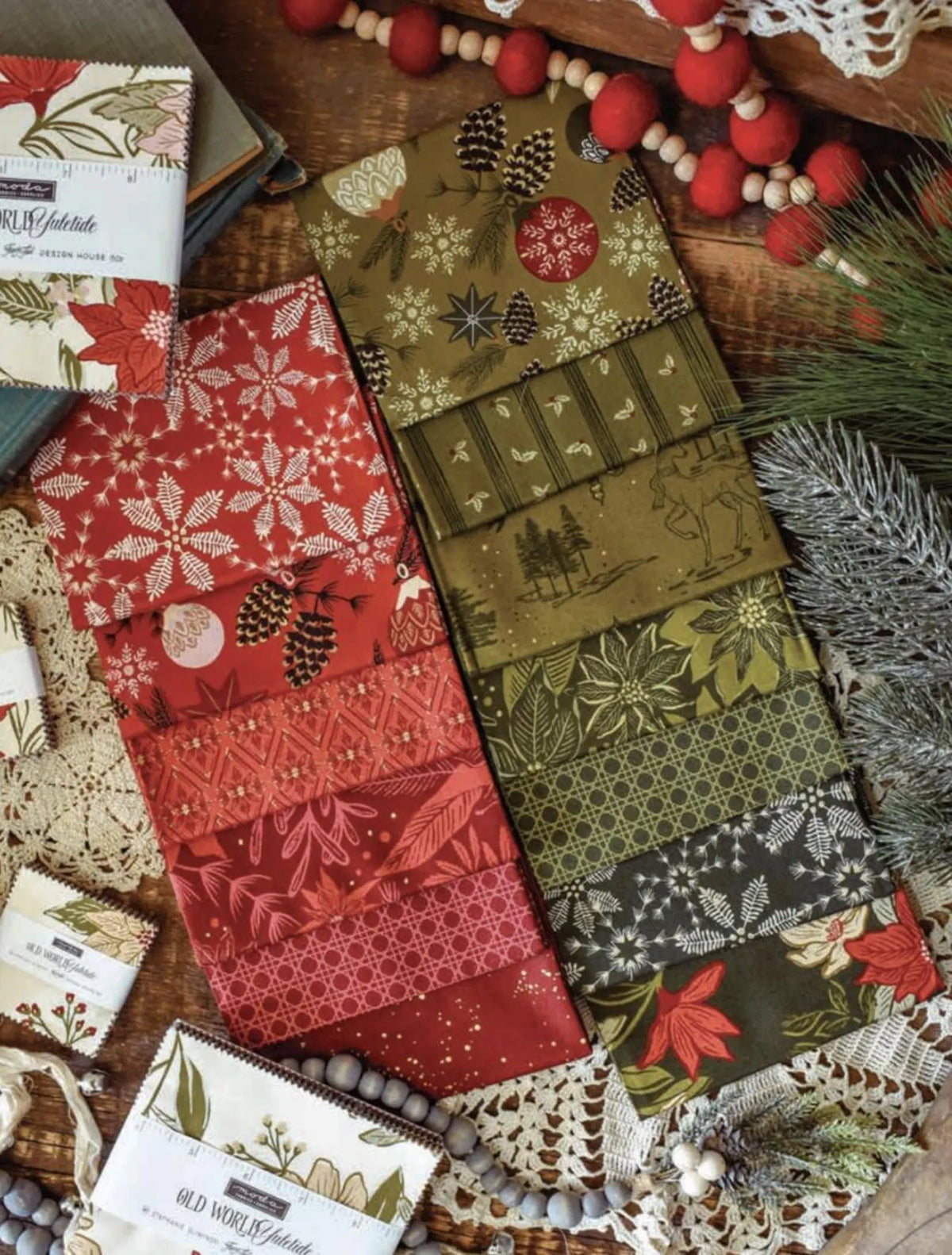 Collection of Christmas-themed fabric swatches on a wooden surface with decorative elements.